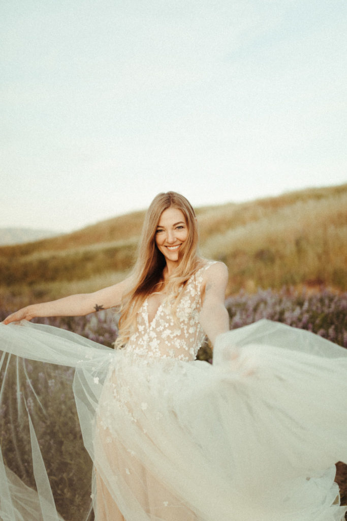 natural candid happy bride running around in her wedding dress in some lupine fields