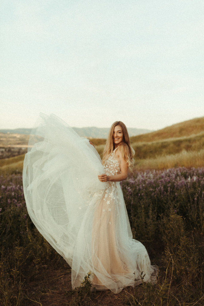 natural candid bride running around in her wedding dress in some lupine fields
