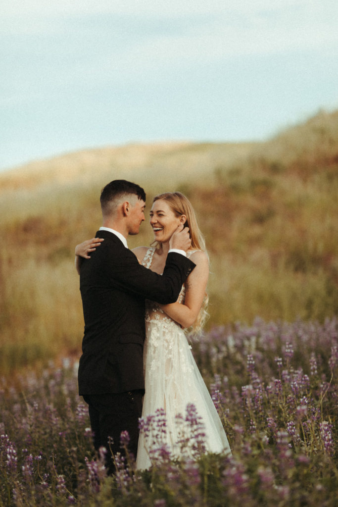 beautiful bride and groom in the iceland lupine fields for their sunrise elopement