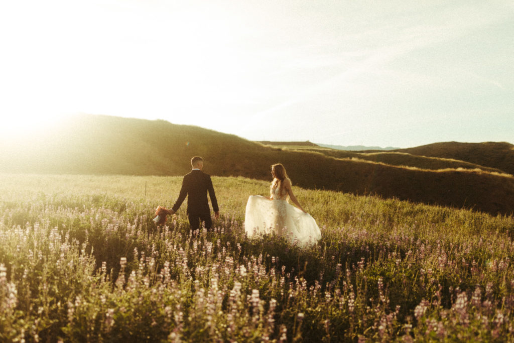 beautiful couple in the fields at sunrise for the wedding elopement