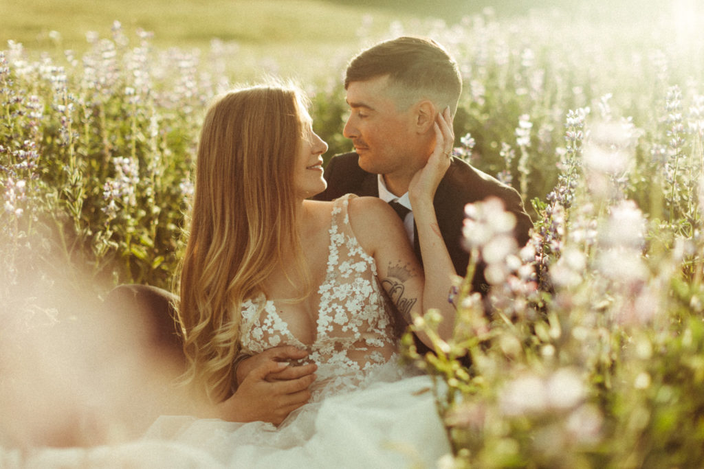 wildly in love couple in a field of lupines on their elopement day