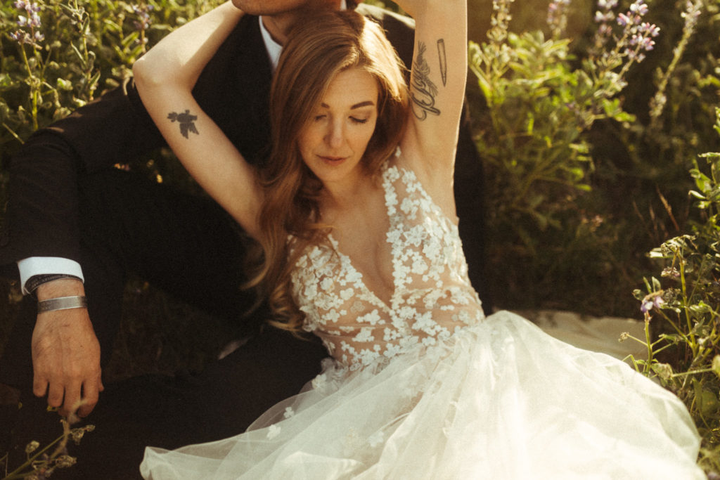 bride with tattoos wearing romantic sheer tulle wedding dress