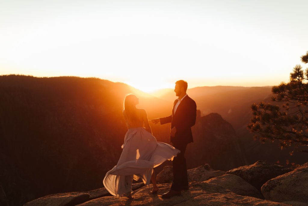 couple dancing during the golden sunset at taft point in yosemite during their adventurous engagement session
