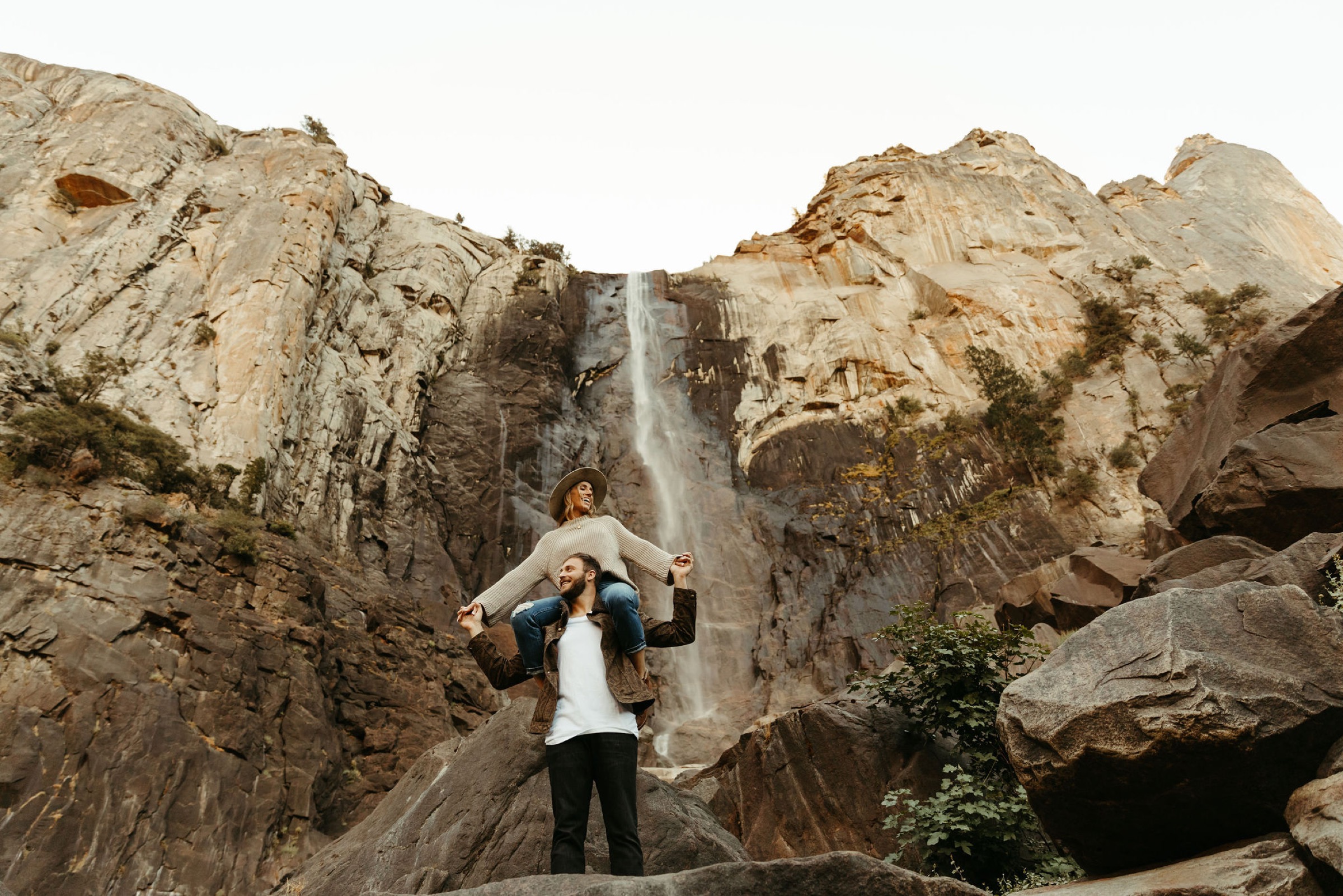 fun engagement photos in yosemite in front of waterfall