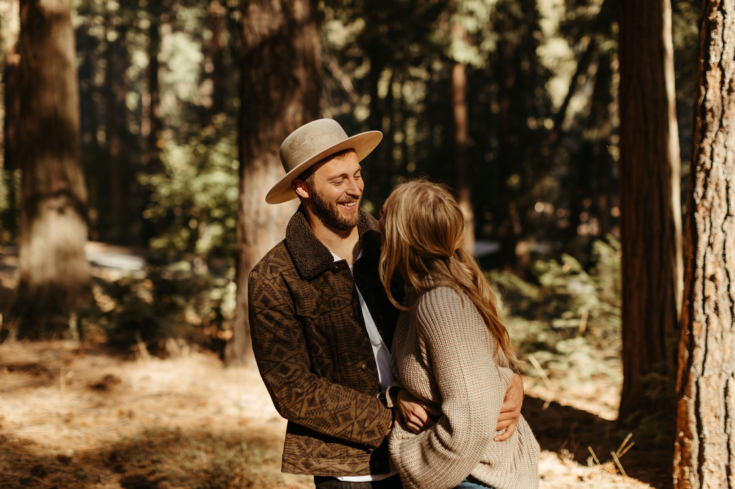 couple in yosemite for their adventurous engagement session wearing fall inspired outfits