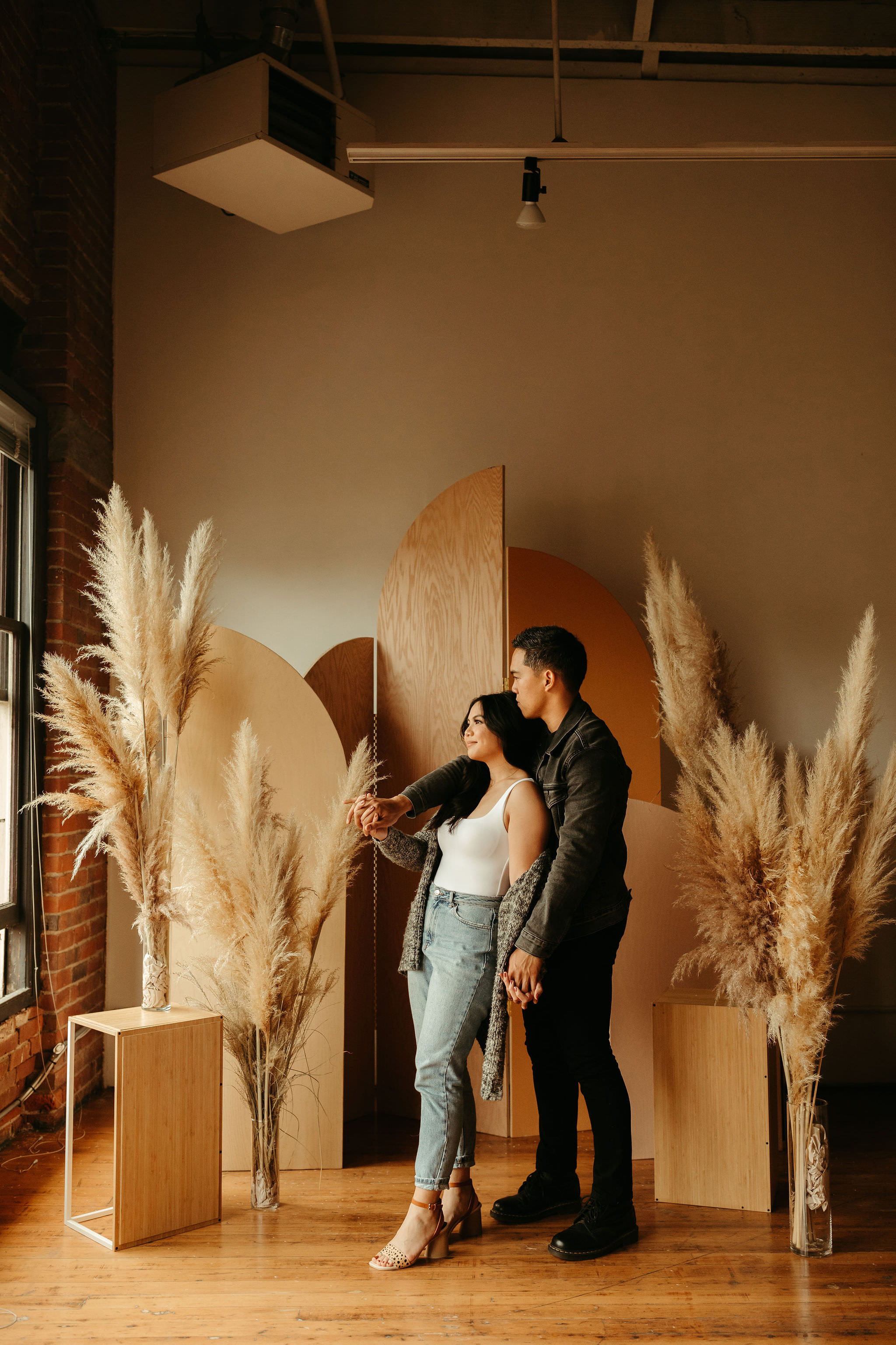 modern engagement session in seattle in studio with brick walls and huge windows