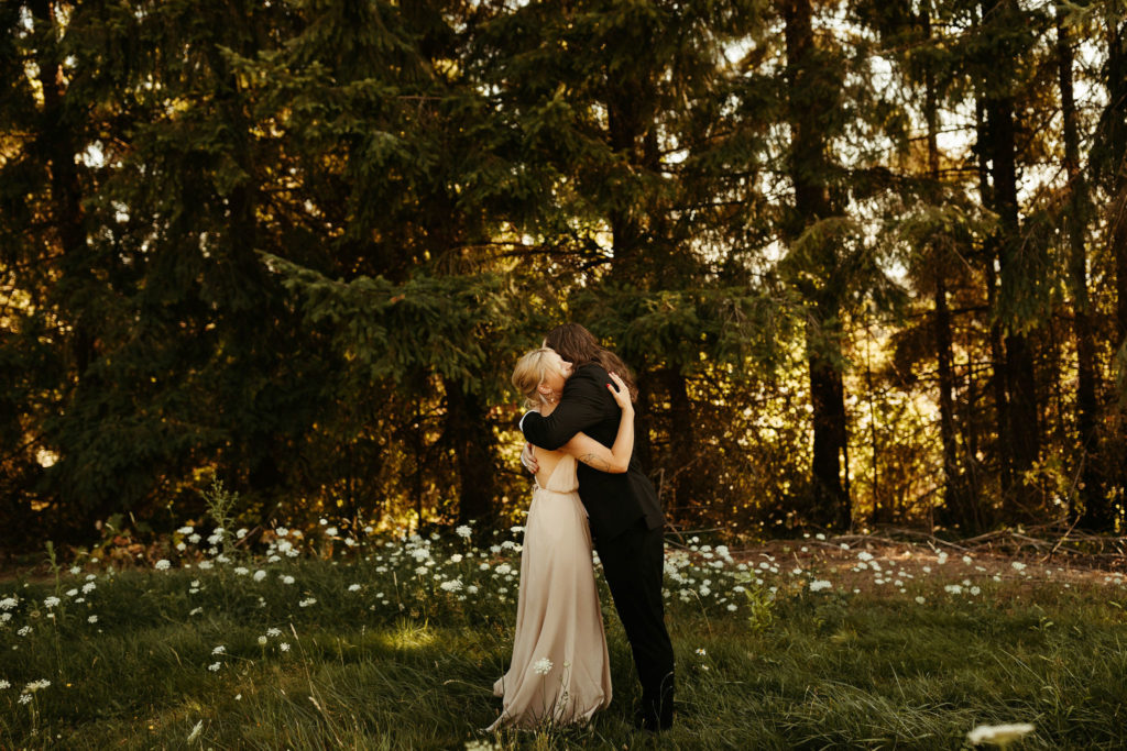 bride and groom hugging in a field of flowers